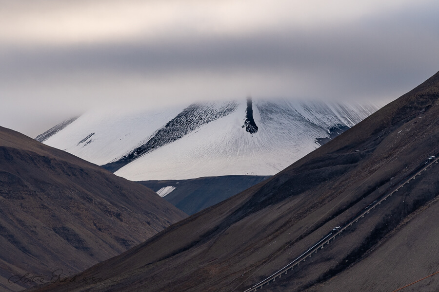 Svalbard_snowcovered_mountain_cloud_foreground_black_mountains_cablecarline900