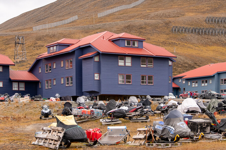 Svalbard_blue_houses_snowmobile_summerparking900