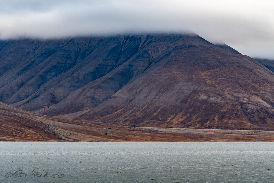 Svalbard_seaside_view_mountains_valley_cabins_clouds900