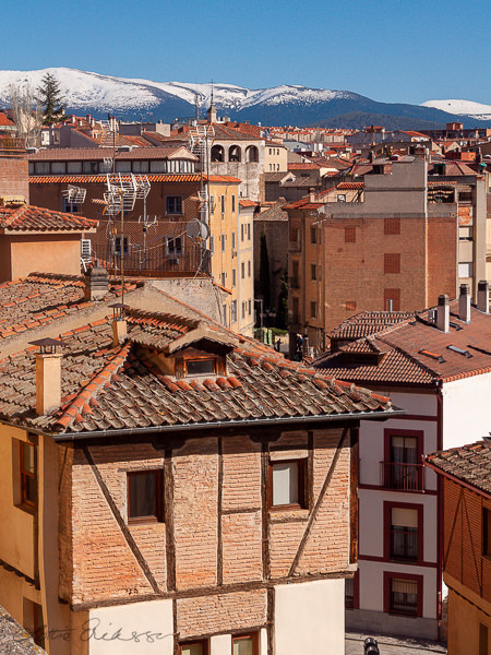 ES_Segovia_brickhouses_tiled_rooftops_snowy_mountain