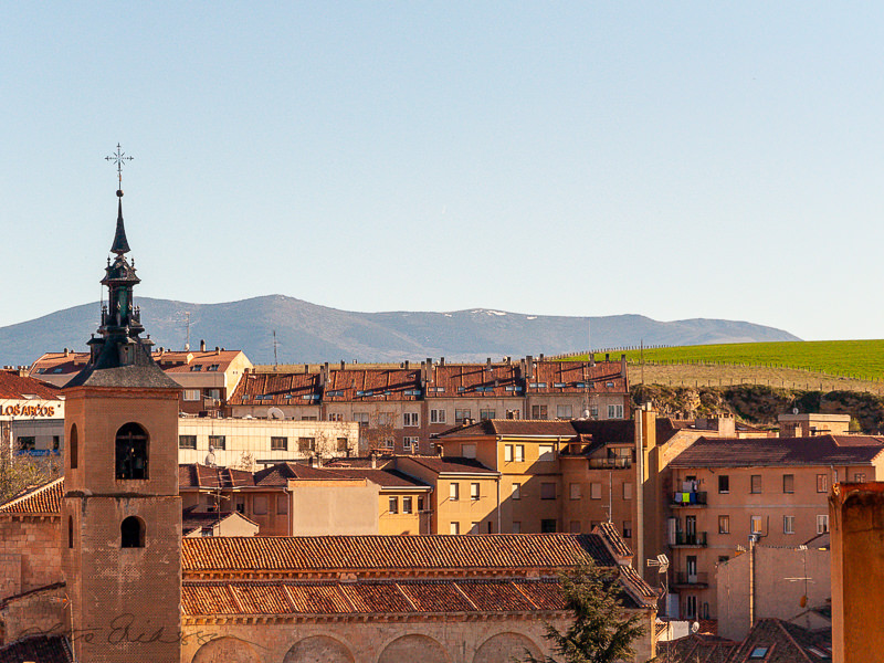 ES_Segovia_churchtower_tiled_rooftops_mountain